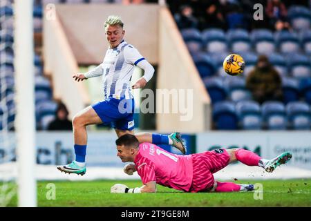 Noah Chilvers von Colchester United versucht einen Torschuss, den Barrow-Torhüter Paul Farman während des Spiels der Sky Bet League Two im JobServe Community Stadium in Colchester retten lässt. Bilddatum: Samstag, 25. November 2023. Stockfoto