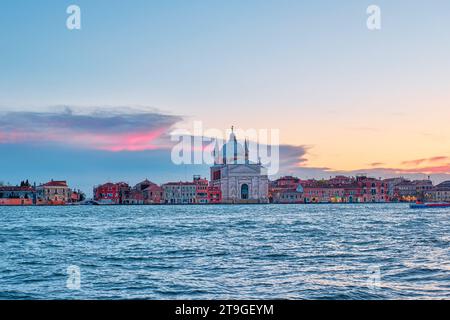 Venedig, Italien - 9. November 2023: Ein wunderschönes Bild der Il Redentore und der Kathedrale von Santissimo über dem Wasser bei Sonnenuntergang Stockfoto