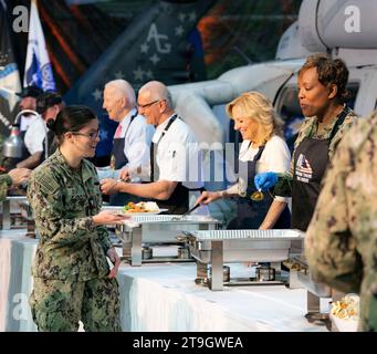 Norfork, Vereinigte Staaten von Amerika. 19. November 2023. Von links nach rechts: US-Präsident Joe Biden, Chefkoch Robert Irvine und First Lady Jill Biden servieren Thanksgiving-Mahlzeiten an Angehörige der Streitkräfte und deren Familien während eines Friendsgiving Dinners in der Naval Station Norfolk, 19. November 2023 in Washington, D.C. die Mahlzeit wurde vom berühmten Chefkoch Robert Irvine veranstaltet. MC2 Porsha Thompson/US Navy Photo/Alamy Live News Stockfoto