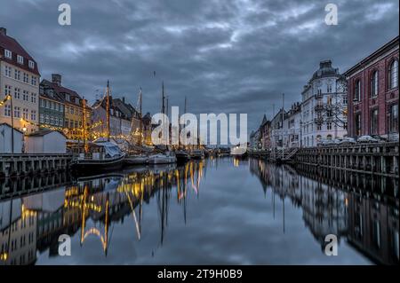 Die Weihnachtsdekoration in Nyhavn spiegelt sich während der blauen Stunde, dem 25. November 2023, im Wasser wider Stockfoto