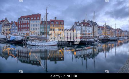 Panorama des Nyhamns-Kanals in kopenhagen während der blauen Stunde mit Booten, die sich im Wasser spiegeln, 25. November 2023 Stockfoto