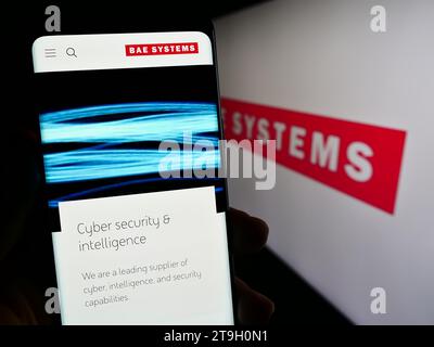 Person, die ein Handy hält, mit Webseite des britischen Luft- und Raumfahrtunternehmens BAE Systems plc vor dem Logo. Konzentrieren Sie sich auf die Mitte des Telefondisplays. Stockfoto