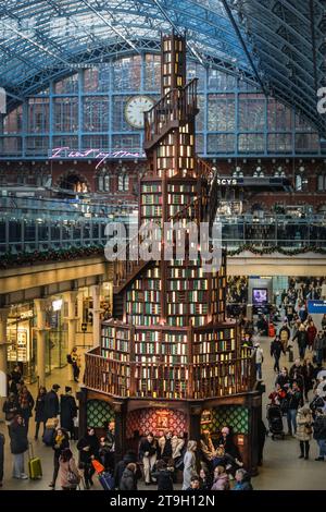 London, Großbritannien. November 2023. Wie es heute eine jährliche Tradition ist, zeigt die St. Pancras International Station wieder einmal einen ungewöhnlichen Weihnachtsbaum. In diesem Jahr haben sie in Zusammenarbeit mit Hatchards, dem ältesten Buchladen Großbritanniens, eine 12 Meter hohe Baumtreppe mit 270 Bücherregalen und fast 4.000 Büchern errichtet. Die Ecken und Nischen erweisen sich als beliebt bei Reisenden, die sich ausruhen oder eine Weile lesen möchten. Quelle: Imageplotter/Alamy Live News Stockfoto