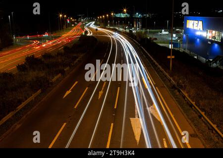 Lange Exposition des Verkehrs bei Nacht von oben auf der Brücke mit Blick auf die A38 in der Nähe von Ikea in Exeter U.K Stockfoto