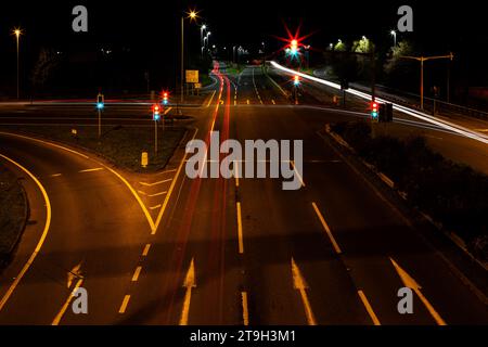 Lange Exposition des Verkehrs bei Nacht von oben auf der Brücke mit Blick auf die A38 in der Nähe von Ikea in Exeter U.K Stockfoto