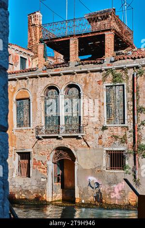 Venedig, Italien - 9. November 2023: Venedig Kanalgewässer, Tor und Graffiti von Banksy, dem Schiffbrüchigen Migrantenkinder Stencil Street Art Stockfoto