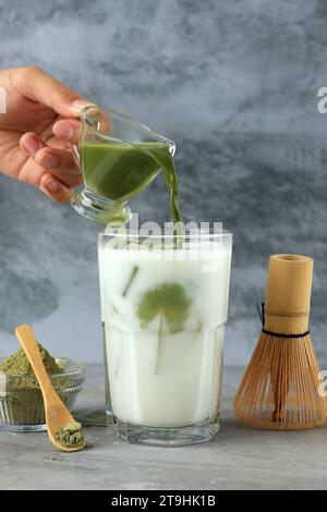 Gieße Matcha in die Milch und mache Green Tea Latte Stockfoto