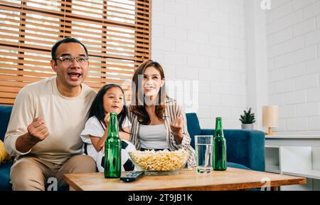 Eine glückliche Familie genießt den Nervenkitzel eines Fußballspiels zu Hause Stockfoto
