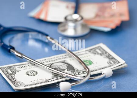Banknoten und Stethoskop. Versorgungsfinanzuntersuchung oder Einsparung für Krankenversicherungskosten Konzept für die Lebensplanung Stockfoto