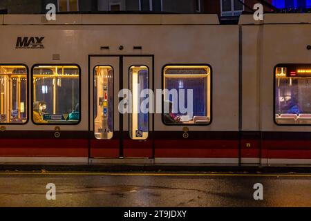 Personen, die in einer regnerischen Nacht in Portland, Oregon, USA mit dem MAX Light Rail Zug fahren {keine Modellveröffentlichungen; nur redaktionelle Lizenzierung] Stockfoto