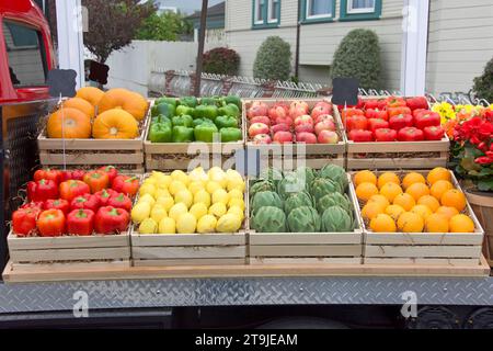 Frische Produkte, Obst und Gemüse, in Schaufelkisten auf der Rückseite eines Lastwagens zum Verkauf auf einem Bauernmarkt in einer Wohngegend. Haus gesehen Stockfoto