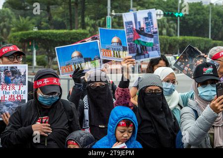 Pro-palästinensische Aktivisten schließen sich Demonstranten an, die am 26./11/2023 auf der Zhongshan South Road in der Nähe des Freiheitsplatzes, des Präsidentenamtes sowie des Außenministeriums in Taipeh (Taiwan) marschieren, um ihre Ablehnung gegen die Verlängerung der Wehrpflicht, die Profitgier im Krieg und die Wettrüste zum Ausdruck zu bringen und sich für Friedensgespräche zwischen Taiwan und China einzusetzen. Der von der Friedens- und Antikriegsplattform, der Parallelregierung, der Linken Allianz und dem Hae Tide Think Tank organisierte Protest hebt die öffentliche Besorgnis über Taiwans geopolitische Haltung und die potenziellen Risiken einer Eskalation der Spannungen in der Taiwan Str hervor Stockfoto