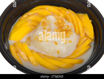 Mango-Kleberreis, ein traditionelles südasiatisches Dessert aus klebrigem Reis, frischer Mango und Kokosmilch, garniert mit knusprigen gelben Mungbohnen. In A Stockfoto