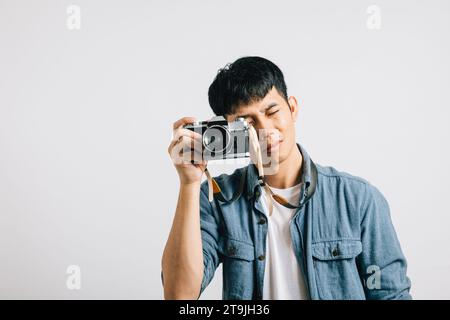 Eine alte Kamera klickt, während ein junger Mann nach einem Fotografen lächelt Stockfoto