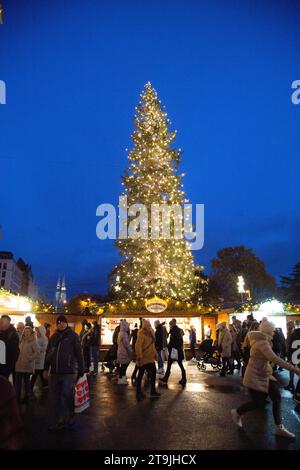 Baum geschmückt mit wunderschönen Weihnachtslichtern auf dem geschäftigen Weihnachtsmarkt (Wiener Christkindlmarkt) im Winter in der Nacht, Rathause, Wien, Österreich Stockfoto