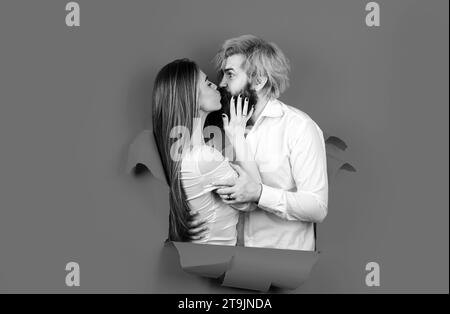 Paar in Loch Papier. Rabatt und Verkauf. Geküsste Paar bärtige Mann und glückliche Frau machen Loch in Papier Kuss durch Loch. Werbetafel, blau Stockfoto