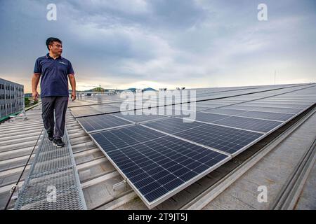 (231126) -- CHONBURI, 26. November 2023 (Xinhua) -- Ein Mitarbeiter patrouilliert am 7. November 2023 auf dem Sonnendach einer Reifenfabrik in der Provinz Chonburi, Thailand. Das chinesische Unternehmen Prinx Chengshan Tire und WHA Utilities and Power (WHAUP) aus Thailand bauen gemeinsam ein Solardach für die Reifenfabrik in der Provinz Chonburi. Die erste Phase des Projekts nahm Ende November 2022 mit einer installierten Kapazität von 19,44 MW ihren Betrieb auf. Die zweite Phase des Projekts wird voraussichtlich 2024 abgeschlossen sein, bis zu dem die installierte Gesamtkapazität 24,24 MW erreichen wird, die 30.000 verringert werden kann Stockfoto