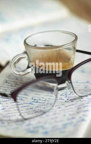 Eine Tasse Kaffee auf einem alten handschriftlichen Manuskript Stockfoto