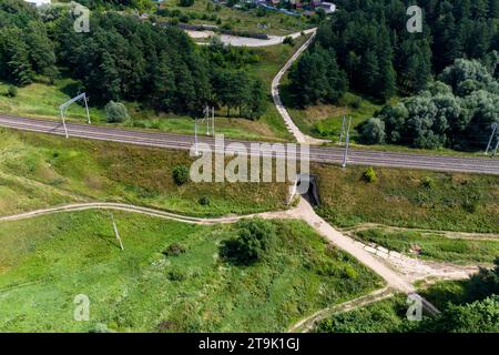 Luftaufnahme eines Bahndamms mit Schienen und Straßentunnel Stockfoto