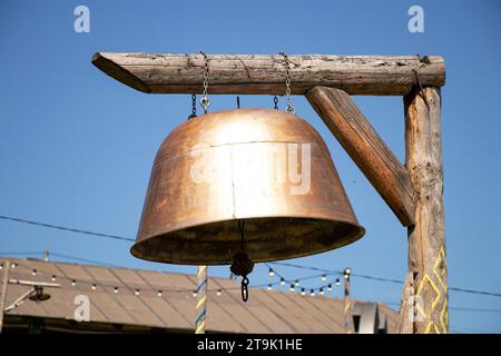 Eine hausgemachte Glocke hängt an einem Holzpfahl in einem Dorf von einer Kelle in der Ukraine in den Karpaten, Kultur und Reisen Stockfoto