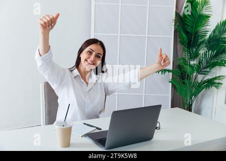 Geschäftsfrau, die gerne im Büro mit Laptop arbeitet Stockfoto