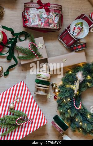 Weihnachtliches Dekor auf dem Boden. Blick von oben auf Weihnachtsgeschenk, Tannenzweig und Schneekugel Stockfoto