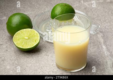 Glas mit Limettensaft, grüner Limette und GlasEntsafter aus nächster Nähe Stockfoto