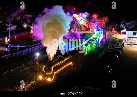 Kingswear, Devon, Großbritannien. November 2023. Der Christmas Train of Lights auf der Dartmouth Steam Railway in Devon, der bis zum 30. Dezember 2023 verkehrt, erreicht den Bahnhof Kingswear nach seiner Reise von Paignton. Die Wagen und Dampflokomotiven des Festdienstes sind innen und außen mit farbigen Lichtern beleuchtet. Bildnachweis: Graham Hunt/Alamy Live News Stockfoto