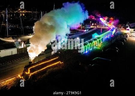 Kingswear, Devon, Großbritannien. November 2023. Der Christmas Train of Lights auf der Dartmouth Steam Railway in Devon, der bis zum 30. Dezember 2023 verkehrt, erreicht den Bahnhof Kingswear nach seiner Reise von Paignton. Die Wagen und Dampflokomotiven des Festdienstes sind innen und außen mit farbigen Lichtern beleuchtet. Bildnachweis: Graham Hunt/Alamy Live News Stockfoto