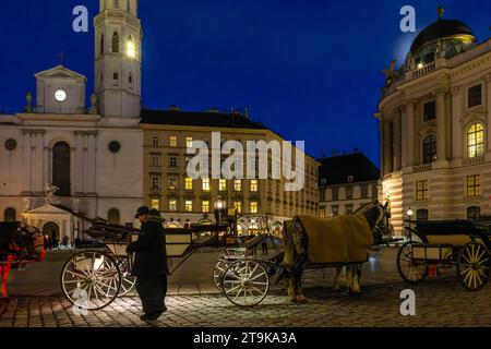 21.11.2023, Österreich, die Hauptstadt Wien. Impressionen vom Michaelerplatz mit der Hofburg und den wartenden Kutschen Fiaker. Kirchturm von Pfarre St. Michael 21.11.2023, Wien in Österreich 21.11.2023, Wien in Österreich *** 21 11 2023, Österreich, die Hauptstadt Wien Impressionen vom Michaelerplatz mit der Hofburg und den Wartewagen Fiakerkirchtenturm St. Michaels Parish 21 11 2023, Wien 21 11 2023, Wien in Österreich Credit: Imago/Alamy Live News Stockfoto