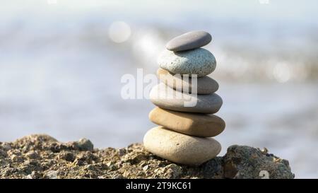 Steinsteinpyramide am Meer. Stapel ausgeglichener Steine am Strand. Stockfoto