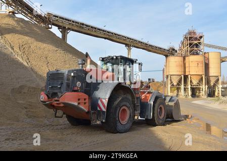 Radlader beladen Lkw mit Kies in einer Sandgrube – Transport und Abbau von Baustoffen für die Bauindustrie Stockfoto