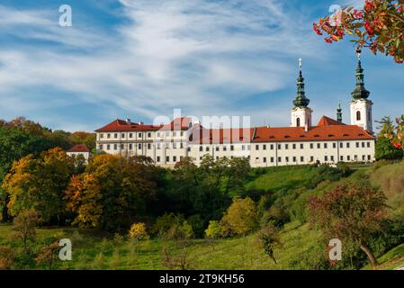 Das Kloster Strahov, ein weißes Gebäude mit rotem Dach, auf einem Hügel in Prag. Stockfoto