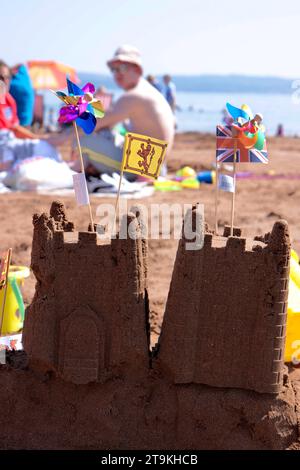 Zwei Sandburgen am Strand im Sommer mit einer britischen und walisischen Flagge oben Stockfoto