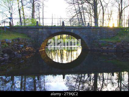 Alte Brücke mit Ziegelmauer und Fluss, der durchfließt. Der Ort ist Bollebygd in Schweden und die Brücke heißt Prästabron. Stockfoto