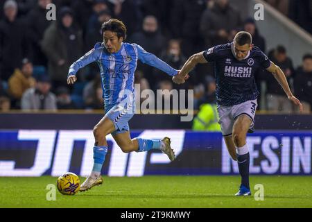 Tatsuhiro Sakamoto von Coventry City (links) und Murray Wallace von Millwall im Sky Bet Championship-Spiel in New den, London. Bilddatum: Samstag, 25. November 2023. Stockfoto