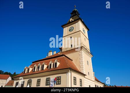 Ein Mann hängt ein Banner am Gebäude des Stadthauses, in dem sich das Geschichtsmuseum der Grafschaft Brașov in Brașov, Rumänien, befindet, 3. August 2023. Stockfoto