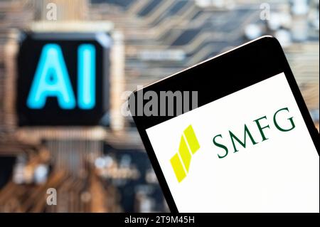 In dieser Fotoabbildung ist das Logo des japanischen multinationalen Banken- und Finanzunternehmens Sumitomo Mitsui Financial Group (SMFG) auf einem Smartphone mit einem Chip und einem Symbol für künstliche Intelligenz (KI) im Hintergrund zu sehen. Stockfoto