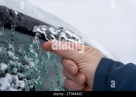 Bayern, Deutschland - 26. November 2023: Ein Mann entfernt Eis und Eiswürfel aus einem Auto. Winter- und Schneekonzept *** ein Mann entfernt Eis und Eiszapfen von einem Auto. Winter und Schnee Konzept Credit: Imago/Alamy Live News Stockfoto