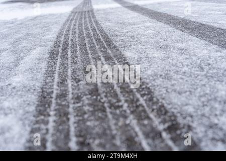 Bayern, Deutschland - 26. November 2023: Schnee und Eis auf einer Straße. Rutschige Straße *** Schnee und Eis auf einer Straße. Glatte Fahrbahn Stockfoto