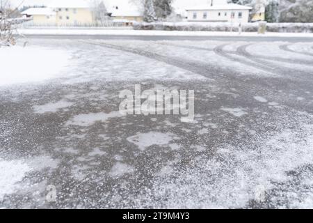 Bayern, Deutschland - 26. November 2023: Schnee und Eis auf einer Straße. Rutschige Straße *** Schnee und Eis auf einer Straße. Glatte Fahrbahn Stockfoto