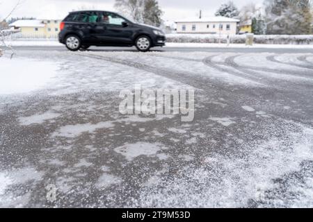 Bayern, Deutschland - 26. November 2023: Schnee und Eis auf einer Straße. Rutschige Straße *** Schnee und Eis auf einer Straße. Glatte Fahrbahn Stockfoto