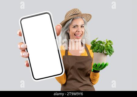 Farmerin Zeigt Ein Riesiges Handy Mit Leerem Bildschirm, Studio Stockfoto