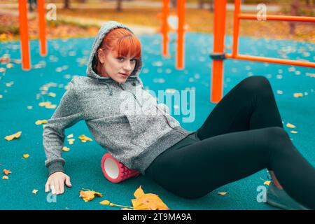 Junge kaukasische Stadtfrau mit Schaumwalze im Herbst im Park Stockfoto