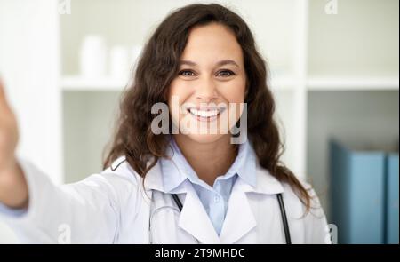 Positive junge Ärztin nimmt Selfie in der Klinik ein Stockfoto