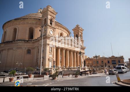 Mosta, Malta - 25. August 2019: Rotunde von Mosta. Außenansicht der Wallfahrtskirche der Himmelfahrt unserer Lieben Frau. Blick auf die Straße mit Menschen und Autos auf der Straße Stockfoto