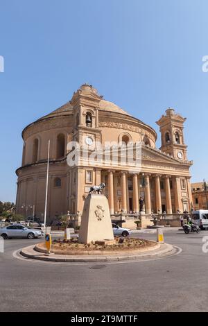 Mosta, Malta - 25. August 2019: Rotunde von Mosta. Außenansicht der Wallfahrtskirche der Himmelfahrt unserer Lieben Frau. Vertikales Straßenfoto mit Personen und Stockfoto