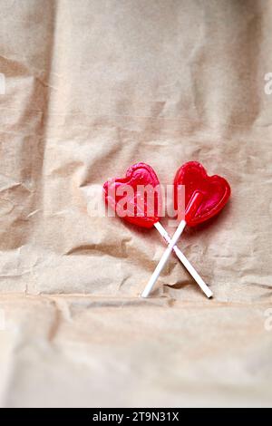 Zwei rote Herzlutscher zusammen auf einem Papphintergrund. Stockfoto
