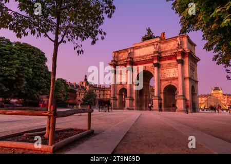 Die Abenddämmerung steigt auf dem Arc de Triomphe du Carrousel ab und lässt einen Zauber strahlender Farbtöne wirken. Stockfoto