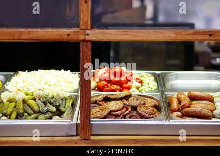 Weihnachtliches Street Food Festival auf Messe im Stadtzentrum, Winterferien. BBQ Street Food zum Verkauf, leckere Würstchen auf dem Holiday Street Market in europa Stockfoto